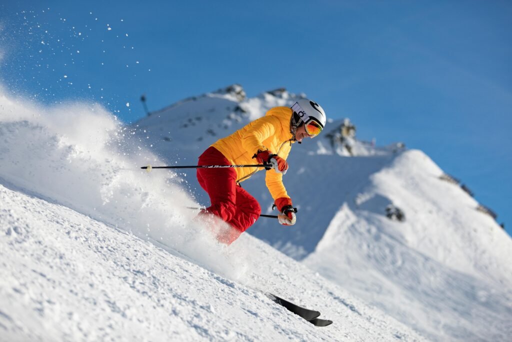 Dynamic capture of a skier racing downhill in snowy mountains, showcasing adrenaline and winter sport excitement.
