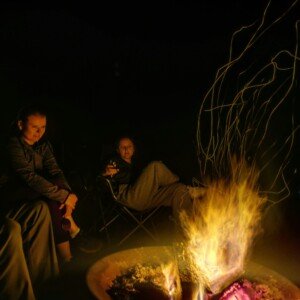 Gathering at night by the outdoor fire pit