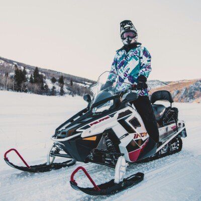 Snowmobile rentals nearby. Man driving snowmobile in the middle of lake